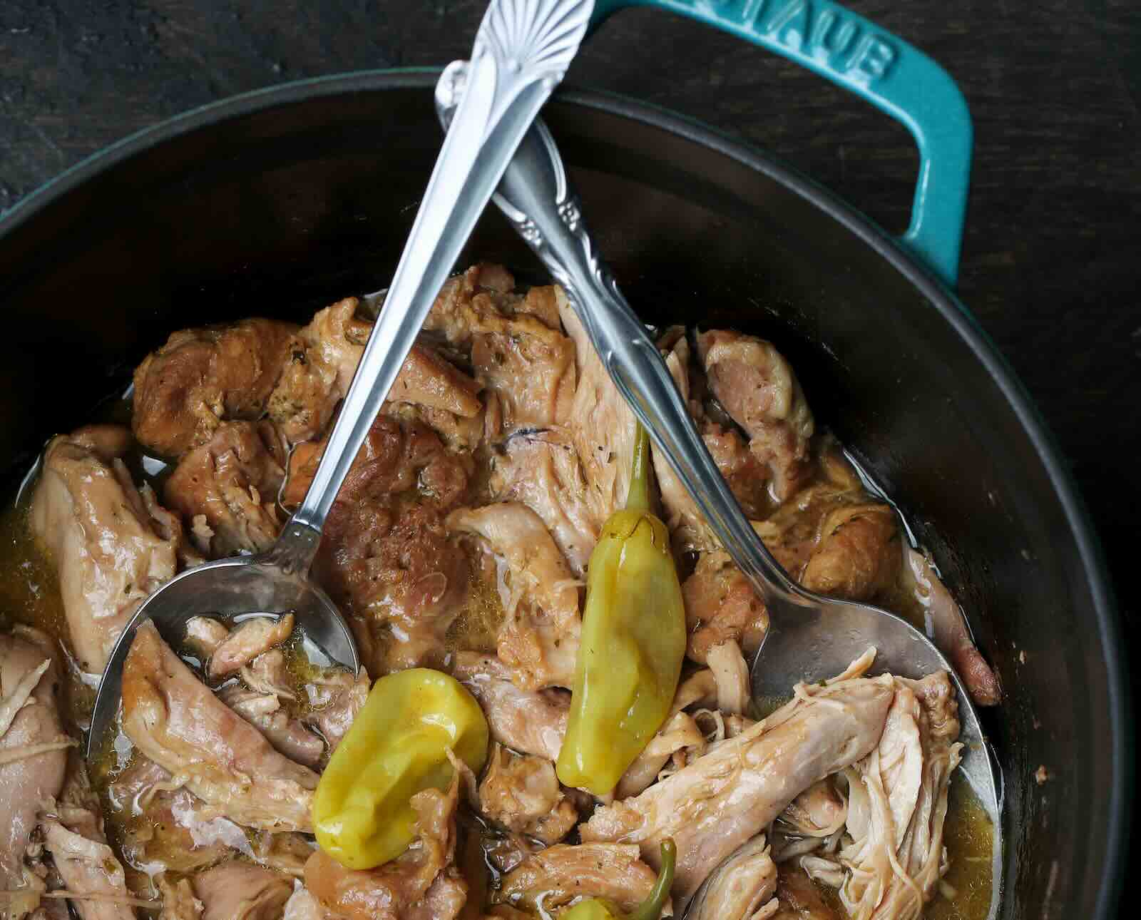 Pot roast in a cast iron pan with turkey and pepperoncini peppers