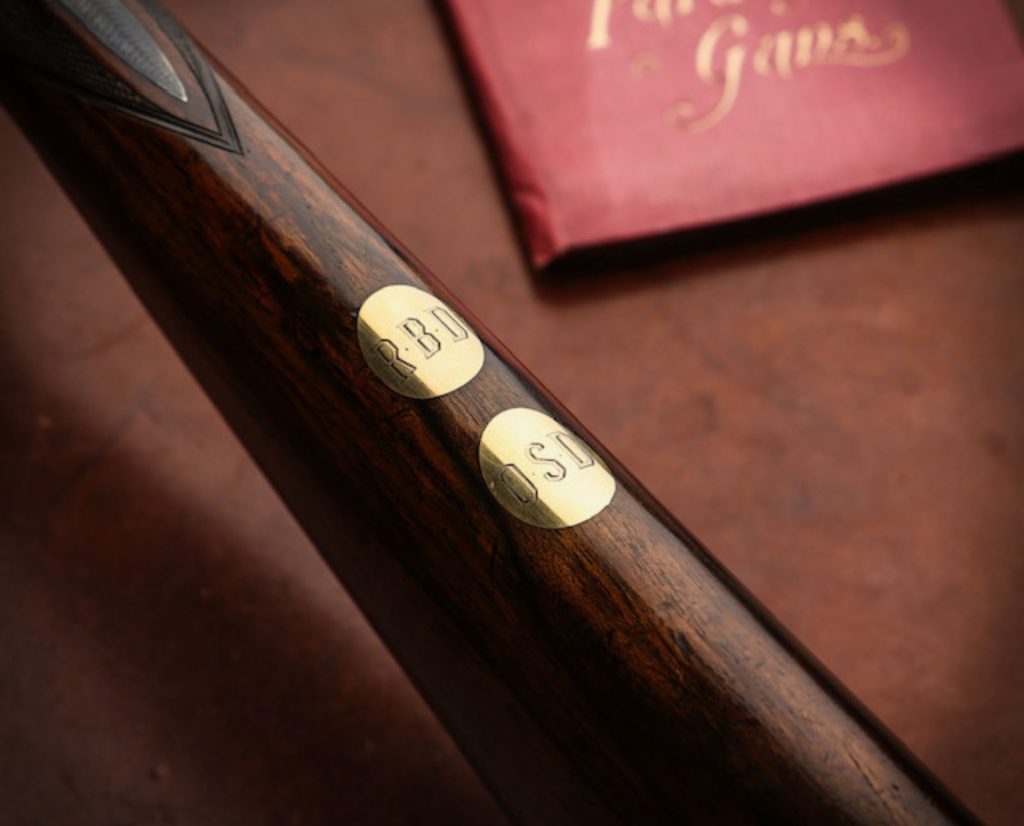 Successive generational monogramming on an heirloom Purdey shotgun escutcheon.
