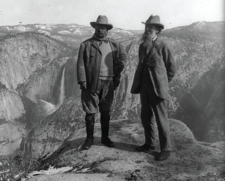 Theodore Roosevelt and John Muir overlooking a national park.