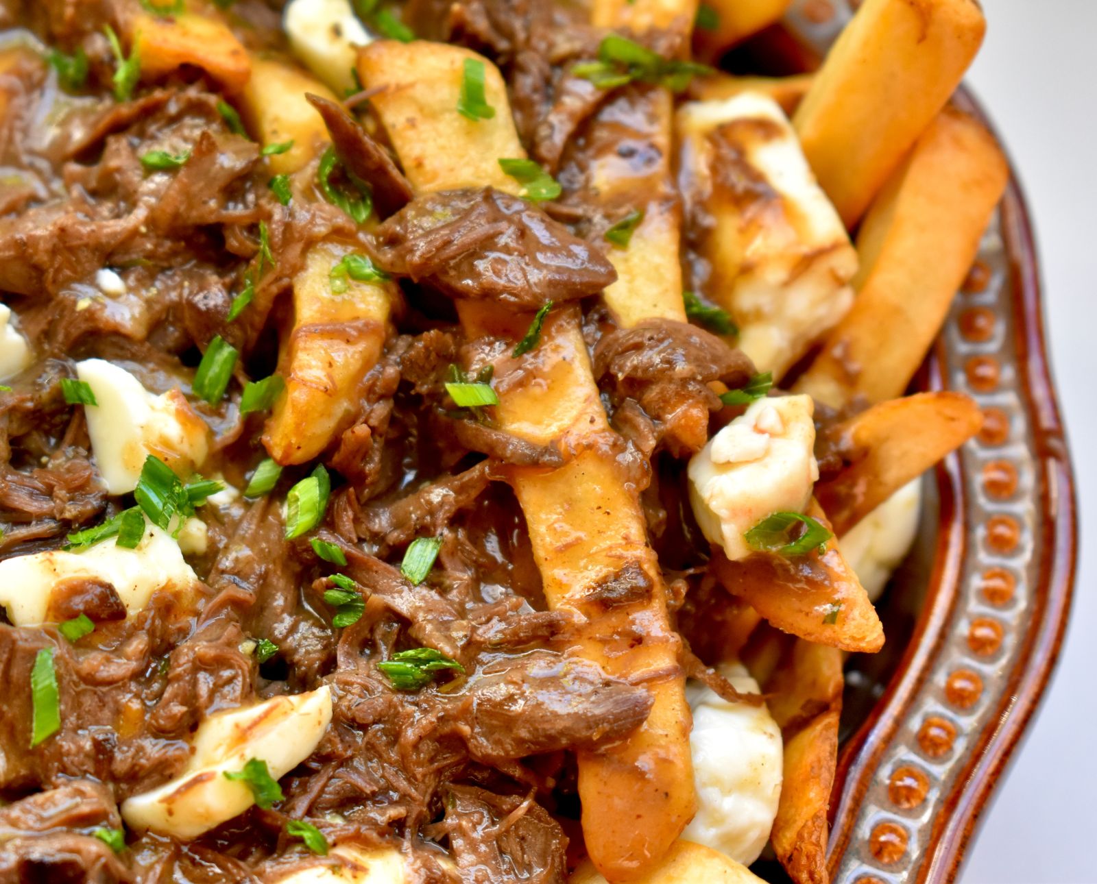 Muskrat gravy poured over fries and cheese curds, a Quebec style poutine recipe.